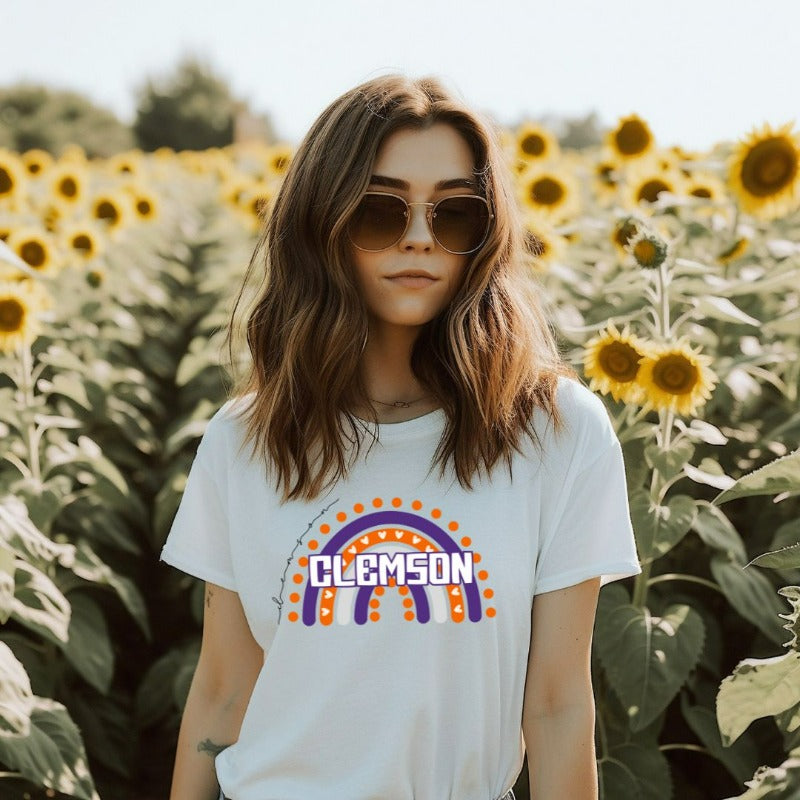 Bella + Canvas 3001 unisex shirt featuring a colorful rainbow design with the word "Clemson" in the center, representing Clemson University on a white graphic tee.