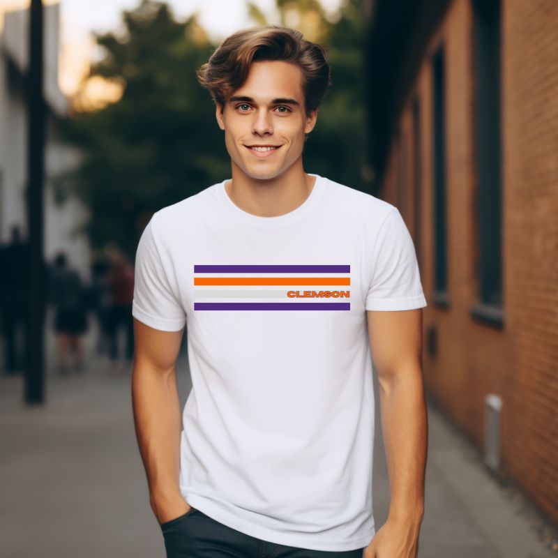 Bella + Canvas 3001 unisex T-shirt featuring a Clemson University design with purple, orange, and grey stripes and the word "Clemson" in bold orange letters on a white shirt