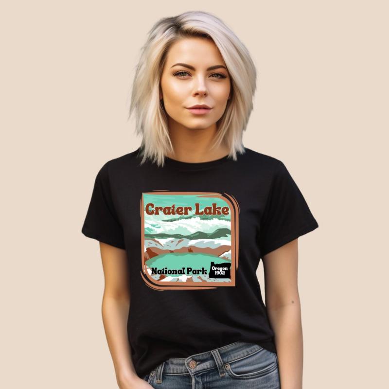 a colorful graphic of Crater Lake National Park, featuring mountains, water, and the text "Crater Lake National Park Oregon 1902 on a black shirt. 