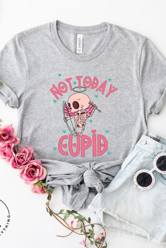 Unleash your rebellious spirit this Valentine's Day with our edgy shirt featuring a skeleton Cupid. The bold "Not Today Cupid" message adds a touch of attitude, making this tee a standout choice for those who march to the beat of their own drum on a grey shirt. 