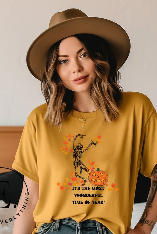Get into the spirit of fall with our Dancing Skeleton T-shirt. This playful shirt features a whimsical skeleton surrounded by falling leaves, on a yellow shirt. 