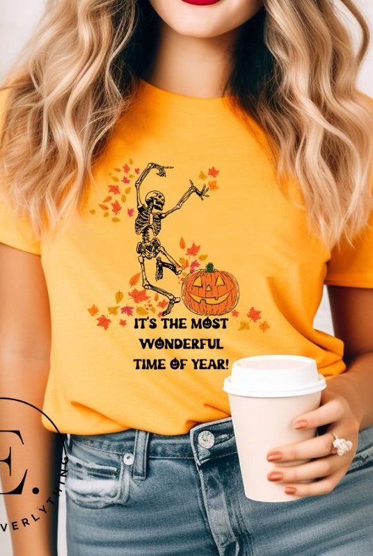 Get into the spirit of fall with our Dancing Skeleton T-shirt. This playful shirt features a whimsical skeleton surrounded by falling leaves, on a mustard colored shirt. 