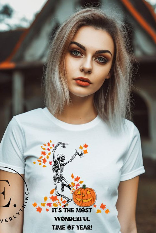 Get into the spirit of fall with our Dancing Skeleton T-shirt. This playful shirt features a whimsical skeleton surrounded by falling leaves, on a white shirt. 