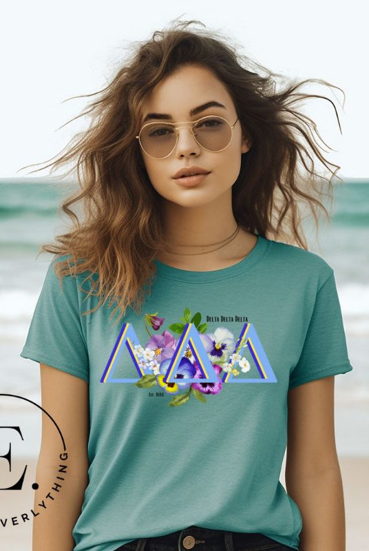 Flaunt your Delta Delta Delta sisterhood with our downloadable PNG sublimation t-shirt design! Featuring the sorority letters and the beautiful pansy on teal shirt. 