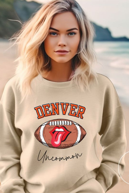 Get ready to show your support for the Denver Broncos in style with our exclusive sweatshirt featuring the team's iconic name and their slogan "uncommon." On a sand colored sweatshirt. 