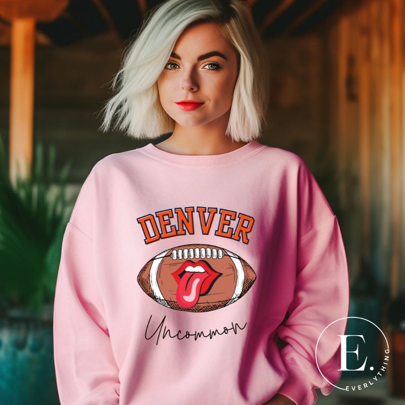 Get ready to show your support for the Denver Broncos in style with our exclusive sweatshirt featuring the team's iconic name and their slogan "uncommon." On a light pink sweatshirt. 