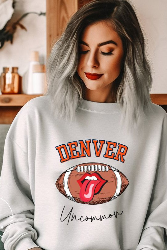 Get ready to show your support for the Denver Broncos in style with our exclusive sweatshirt featuring the team's iconic name and their slogan "uncommon." On a grey sweatshirt. 