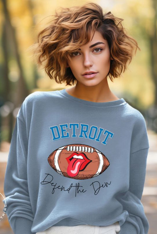 Get ready to show your Detroit Lions pride with this stylish sweatshirt featuring a football and playful lips and tongue design. Complete with the team's slogan "Defend the Den" and the iconic Detroit wordmark, this cozy blue sweatshirt. 