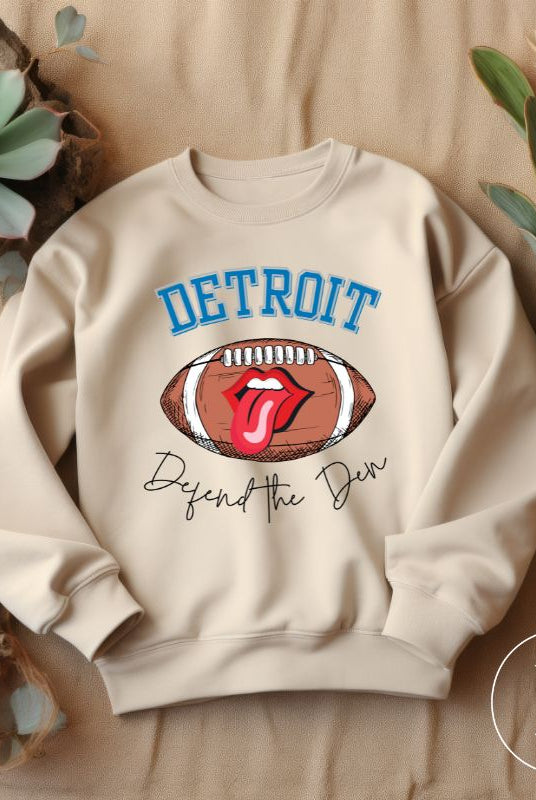 Get ready to show your Detroit Lions pride with this stylish sweatshirt featuring a football and playful lips and tongue design. Complete with the team's slogan "Defend the Den" and the iconic Detroit wordmark, this cozy  sand colored sweatshirt. 