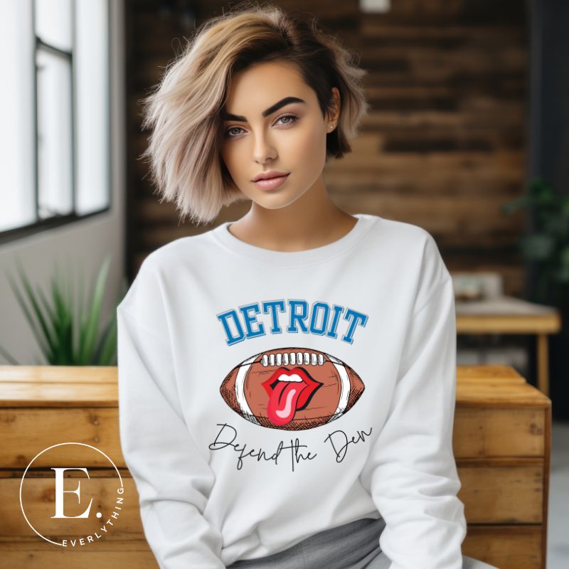 Get ready to show your Detroit Lions pride with this stylish sweatshirt featuring a football and playful lips and tongue design. Complete with the team's slogan "Defend the Den" and the iconic Detroit wordmark, this cozy white sweatshirt. 