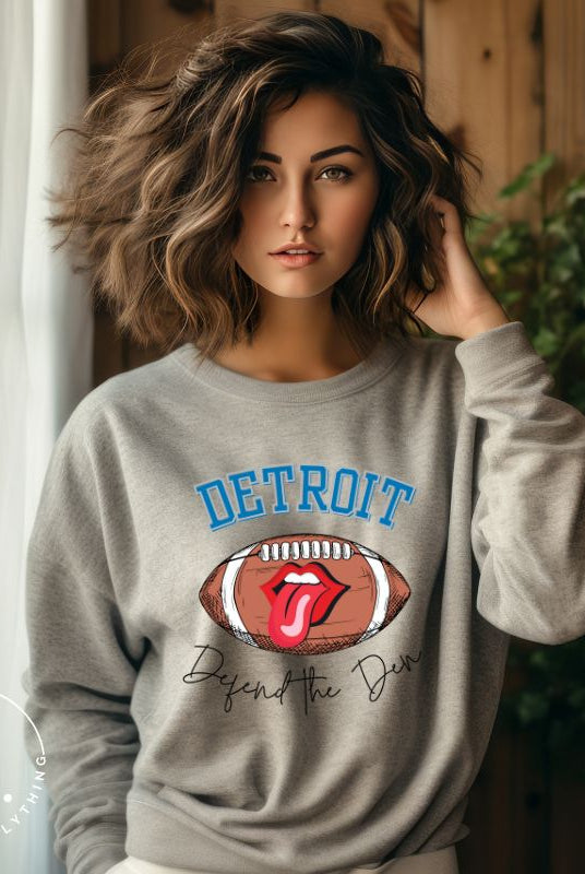 Get ready to show your Detroit Lions pride with this stylish sweatshirt featuring a football and playful lips and tongue design. Complete with the team's slogan "Defend the Den" and the iconic Detroit wordmark, this cozy grey sweatshirt. 