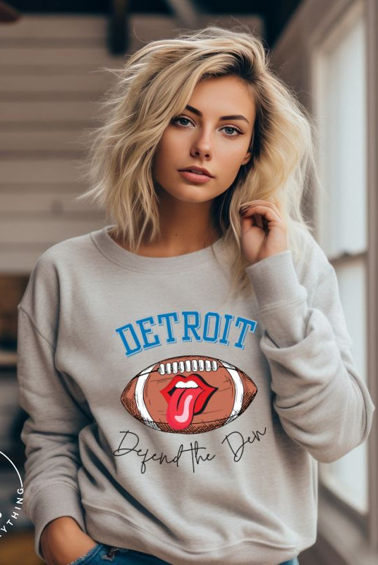 Get ready to show your Detroit Lions pride with this stylish sweatshirt featuring a football and playful lips and tongue design. Complete with the team's slogan "Defend the Den" and the iconic Detroit wordmark, this cozy  grey sweatshirt.