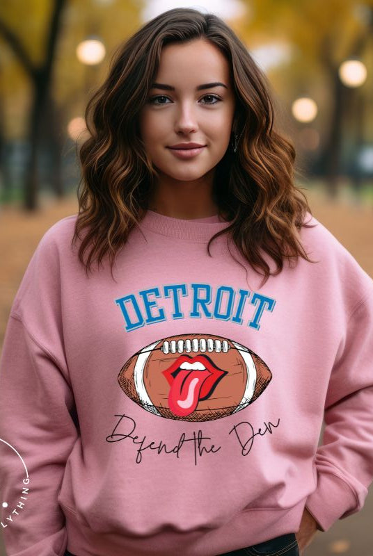Get ready to show your Detroit Lions pride with this stylish sweatshirt featuring a football and playful lips and tongue design. Complete with the team's slogan "Defend the Den" and the iconic Detroit wordmark, this cozy  pink sweatshirt. 