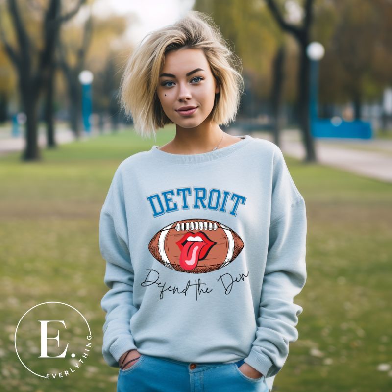 Get ready to show your Detroit Lions pride with this stylish sweatshirt featuring a football and playful lips and tongue design. Complete with the team's slogan "Defend the Den" and the iconic Detroit wordmark, this cozy  blue sweatshirt. 