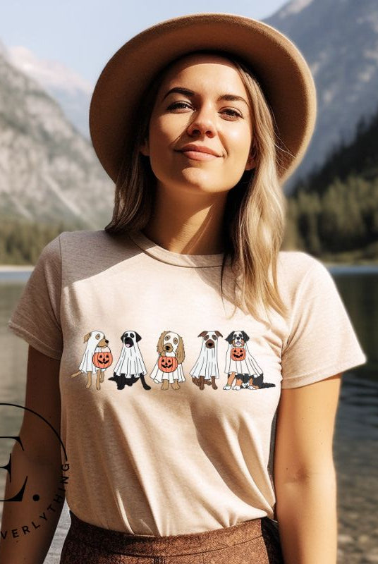 Are you excited for Halloween? Our t-shirt featuring five adorable dogs dressed as ghosts and going trick-or-treating is the perfect way to get into the festive spirit! Whether you're a dog lover or a Halloween enthusiast, on a cream colored shirt.