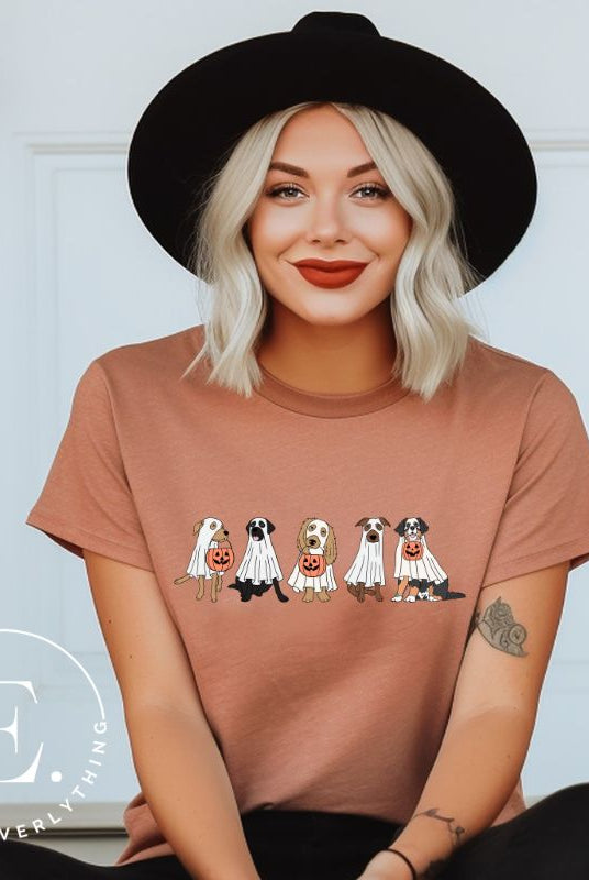 Are you excited for Halloween? Our t-shirt featuring five adorable dogs dressed as ghosts and going trick-or-treating is the perfect way to get into the festive spirit! Whether you're a dog lover or a Halloween enthusiast, on a mauve shirt. 