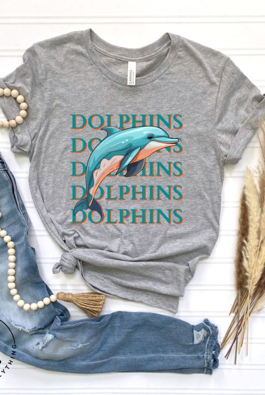 Introducing the Bella Canvas 3001 unisex graphic t-shirt that will make a splash! Dive into style with our Dolphins Dolphins Dolphins Dolphins tee, featuring a playful illustration of a dolphin for the Miami Dolphins football team on a grey shirt. 