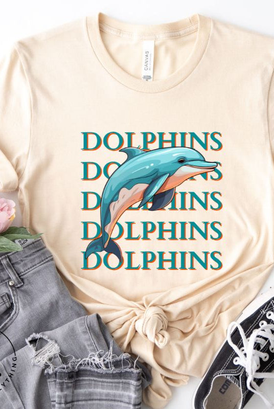 Introducing the Bella Canvas 3001 unisex graphic t-shirt that will make a splash! Dive into style with our Dolphins Dolphins Dolphins Dolphins tee, featuring a playful illustration of a dolphin for the Miami Dolphins football team on a soft cream shirt. 