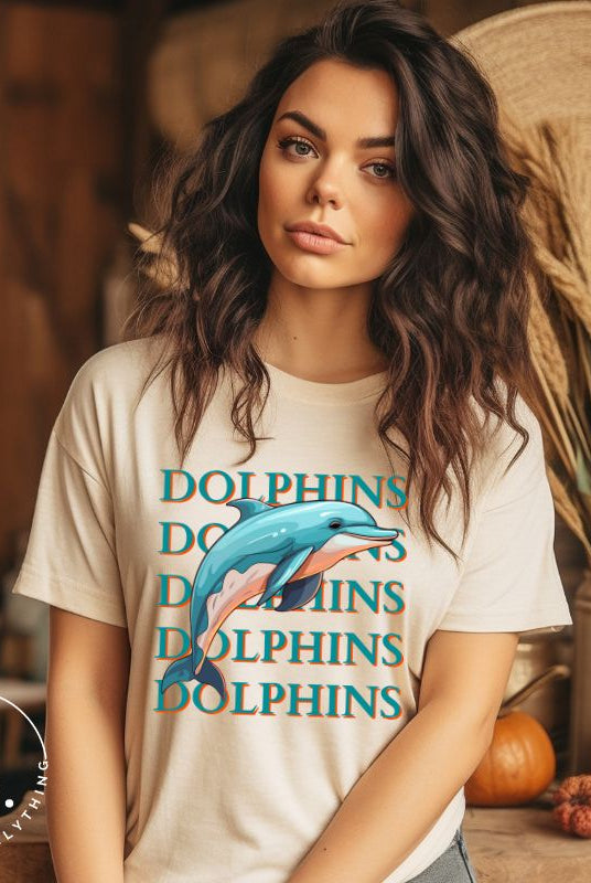 Introducing the Bella Canvas 3001 unisex graphic t-shirt that will make a splash! Dive into style with our Dolphins Dolphins Dolphins Dolphins tee, featuring a playful illustration of a dolphin for the Miami Dolphins football team on a tan shirt. 