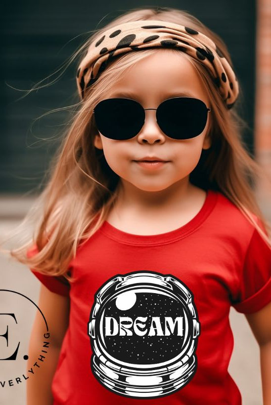 Inspire your little space explorer with our astronaut helmet tee featuring the word 'dream' on the visor on a red shirt. 