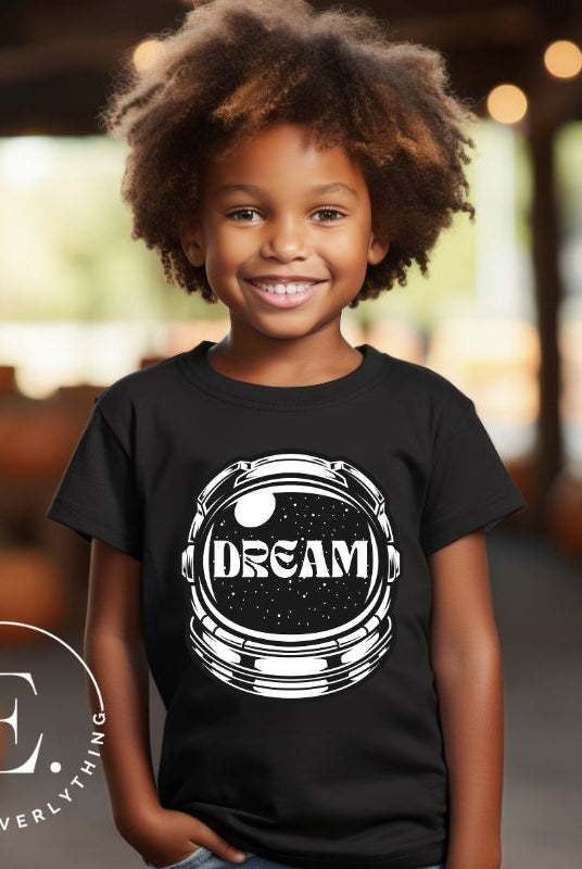 Inspire your little space explorer with our astronaut helmet tee featuring the word 'dream' on the visor on a black shirt. 