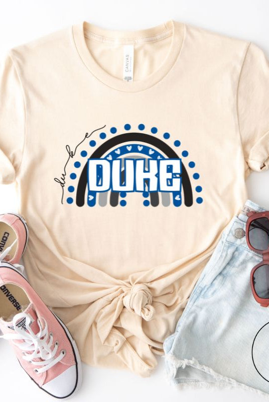 Celebrate diversity and show your support for Duke University with our eye-catching college t-shirt. Our shirt features the Duke colors on a captivating rainbow design, embodying the spirit of inclusion and unity with the iconic Duke wordmark atop the rainbow on a soft cream shirt. 