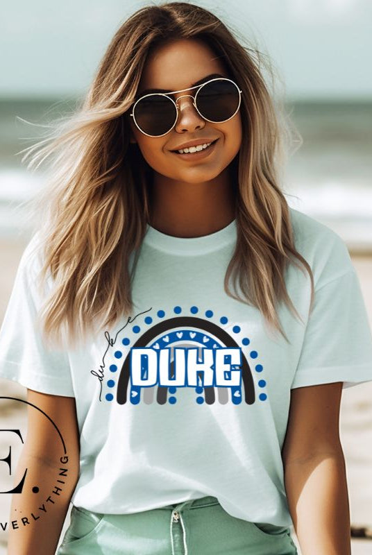 Celebrate diversity and show your support for Duke University with our eye-catching college t-shirt. Our shirt features the Duke colors on a captivating rainbow design, embodying the spirit of inclusion and unity with the iconic Duke wordmark atop the rainbow on a mint colored shirt. 