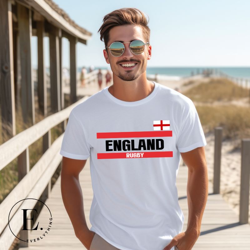 Introducing our England Rugby Graphic T-Shirt - made for rugby fans who want to show off their pride in a stylish and contemporary way! Featuring the words "England Rugby" and the iconic England flag,  on a white shirt. 