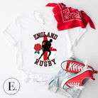 Introducing our England Rugby Graphic T-Shirt - the ultimate fusion of patriotism, rugby pride, and contemporary style! This captivating t-shirt features the words "England Rugby" and the iconic England flag artfully incorporated within the outline of the country, accompanied by a dynamic rugby player graphic on a white shirt. 