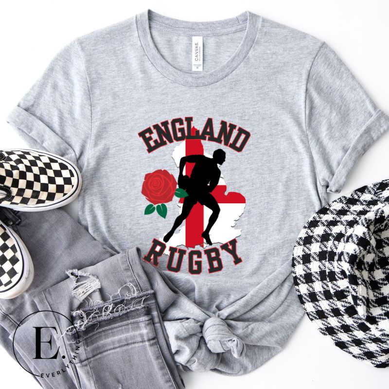 Introducing our England Rugby Graphic T-Shirt - the ultimate fusion of patriotism, rugby pride, and contemporary style! This captivating t-shirt features the words "England Rugby" and the iconic England flag artfully incorporated within the outline of the country, accompanied by a dynamic rugby player graphic on a grey shirt. 