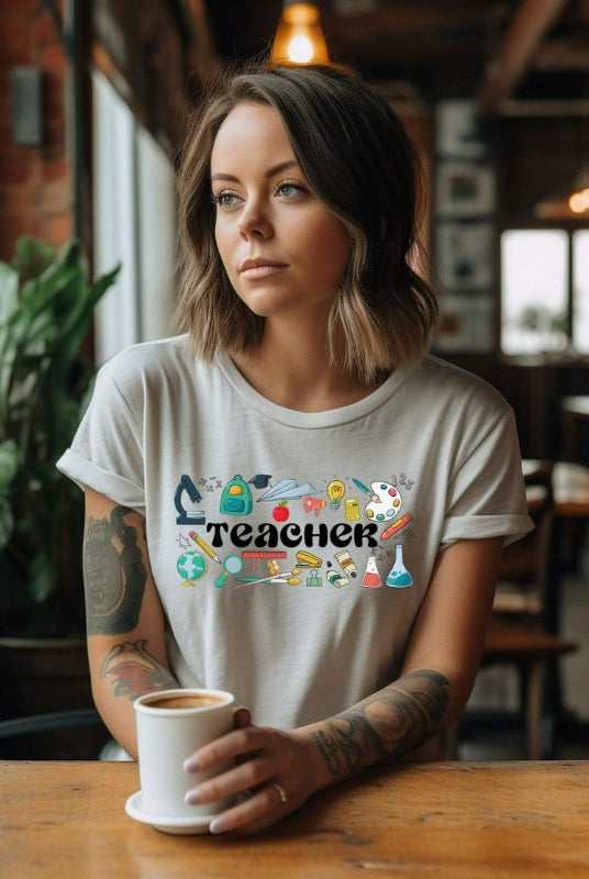 Teacher-themed graphic tee featuring the word 'Teacher' surrounded by all things related to teaching. Perfect for teacher shirts and teacher gifts. White graphic tees. 