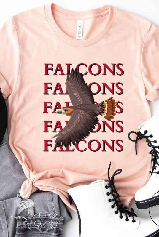 Get ready to soar with style in our Bella Canvas 3001 unisex graphic t-shirt! Featuring a bold Falcon illustration, on a heather prism peach shirt. 