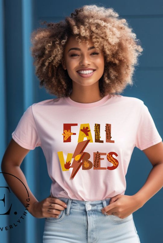 Get into the autumn spirit with our Fall Vibes shirt. Featuring the words 'Fall Vibes' with a creative twist- a lighting bolt replacing the 'I'- this shirt captures the energy of the season. Adorned with leaves, it adds a touch of nature's beauty on a pink shirt. 