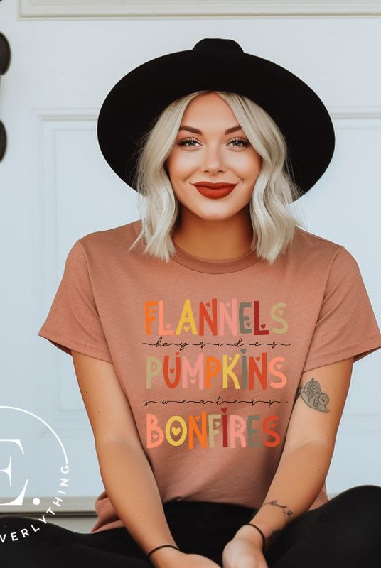 Embrace the cozy spirit of fall with our Flannel, Hayrides, Pumpkins, Sweaters, Bonfires shirt. Featuring the iconic fall elements, this shirt celebrates the season of warmth and comfort on a mauve shirt. 