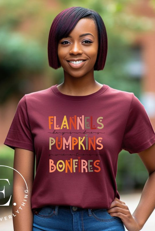 Embrace the cozy spirit of fall with our Flannel, Hayrides, Pumpkins, Sweaters, Bonfires shirt. Featuring the iconic fall elements, this shirt celebrates the season of warmth and comfort on a maroon shirt. 
