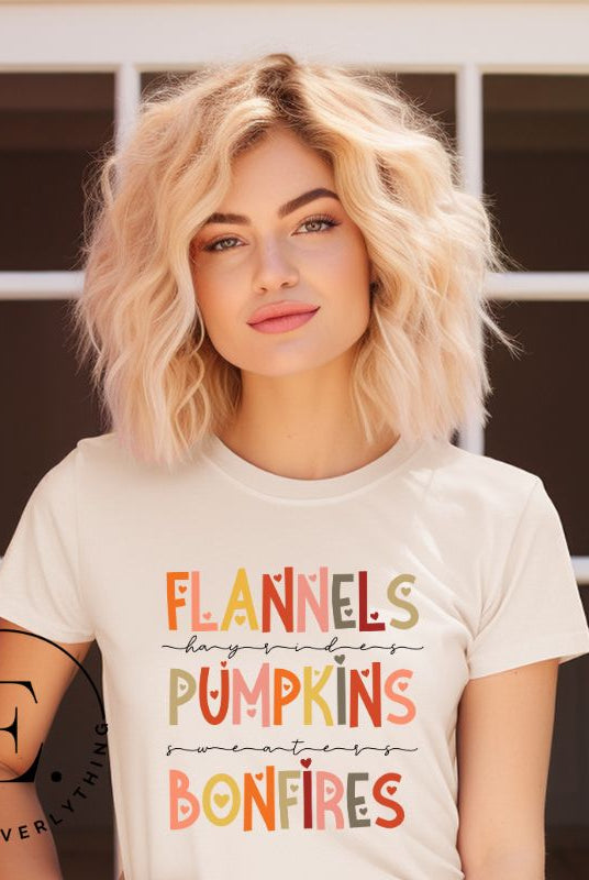 Embrace the cozy spirit of fall with our Flannel, Hayrides, Pumpkins, Sweaters, Bonfires shirt. Featuring the iconic fall elements, this shirt celebrates the season of warmth and comfort on a soft cream shirt. 