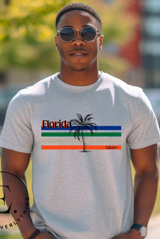 Celebrate your love for the Florida Gators with our modern-inspired retro t-shirt. It captures the essence of campus life, featuring school colors in lines and a palm tree motif on a grey shirt. 