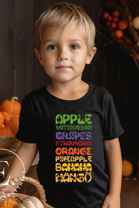Our kid's shirt adds a burst of fruit fun! It features a colorful list of fruits, promoting healthy eating playfully on a black shirt. 