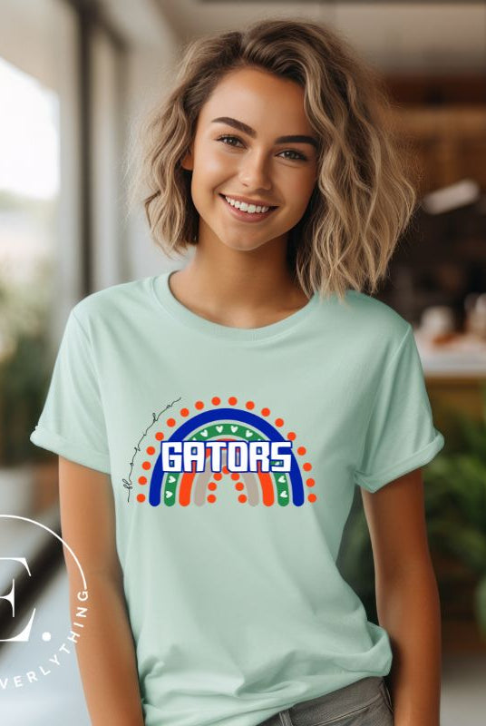 Show off your UF spirit in style with this boho-inspired t-shirt from the University of Florida. The UF colors stands out on this vibrant rainbow background, displaying the school's mascot name in a trendy and unique way on a mint shirt. 