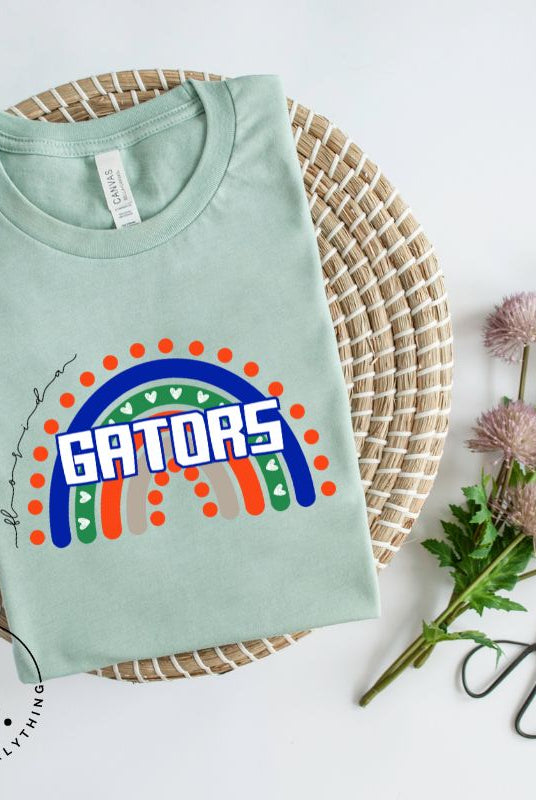 Show off your UF spirit in style with this boho-inspired t-shirt from the University of Florida. The UF colors stands out on this vibrant rainbow background, displaying the school's mascot name in a trendy and unique way on a mint shirt. 