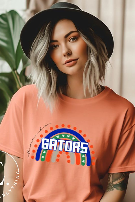 Show off your UF spirit in style with this boho-inspired t-shirt from the University of Florida. The UF colors stands out on this vibrant rainbow background, displaying the school's mascot name in a trendy and unique way on a peach shirt. 