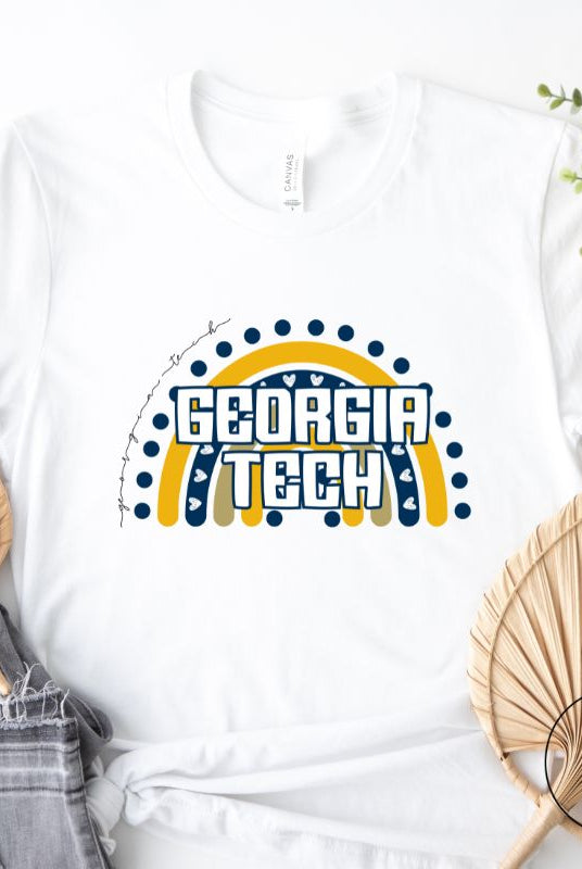 Elevate your Georgia Tech pride with this boho-inspired university t-shirt. The Georgia Tech colors shine through on a vibrant rainbow background, showcasing the school's name in a trendy and unique way on a white shirt. 