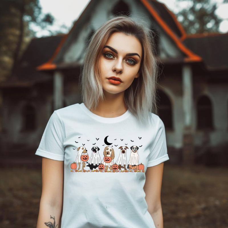 White t-shirt featuring a row of dogs dressed in ghost costumes with pumpkins, perfect for Halloween fun and dog lovers.