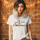 White t-shirt featuring a row of dogs dressed in ghost costumes with pumpkins, perfect for Halloween fun and dog lovers.