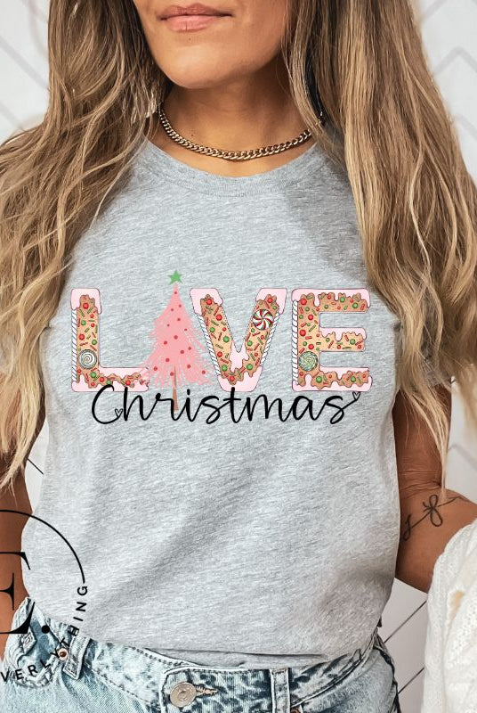 Get ready to celebrate the holiday season in style with our Christmas shirt featuring cute gingerbread cookies arranged to spell out the word "Love" on a grey colored shirt.