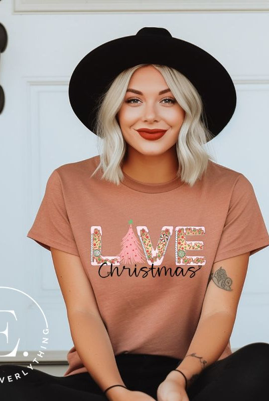 Get ready to celebrate the holiday season in style with our Christmas shirt featuring cute gingerbread cookies arranged to spell out the word "Love" on a mauve colored shirt.
