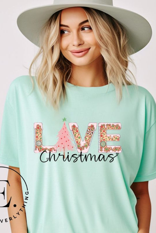 Get ready to celebrate the holiday season in style with our Christmas shirt featuring cute gingerbread cookies arranged to spell out the word "Love" on a mint colored shirt.