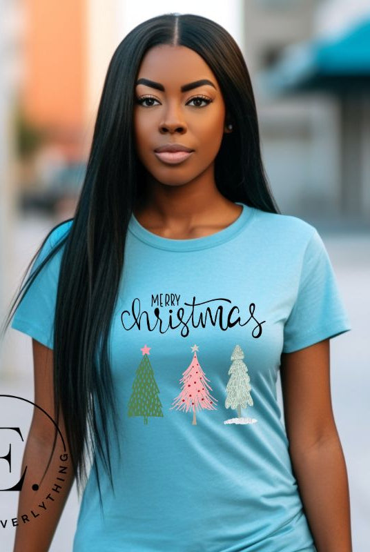 Elevate your festive wardrobe with our trendy shirt and make a chic statement this Christmas. The design features a stylish "Merry Christmas" message along with modern pink and teal Christmas trees, adding a fresh twist to the holiday season on blue shirt. 
