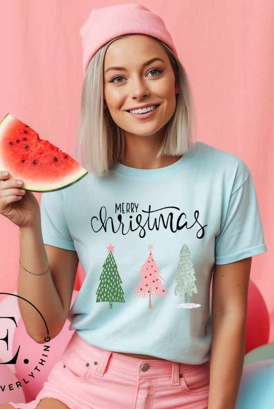 Elevate your festive wardrobe with our trendy shirt and make a chic statement this Christmas. The design features a stylish "Merry Christmas" message along with modern pink and teal Christmas trees, adding a fresh twist to the holiday season on a blue shirt. 