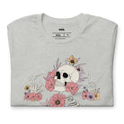 Grey t-shirt featuring a detailed skeleton design with ribcage and hands intertwined with soft, colorful flowers, blending gothic and floral aesthetics.